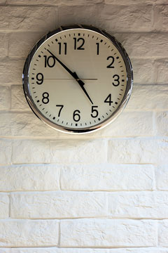 clock on a white brick wall
