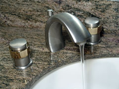 brushed nickel bathroom faucet on granite countertop with undermount porcelain sink