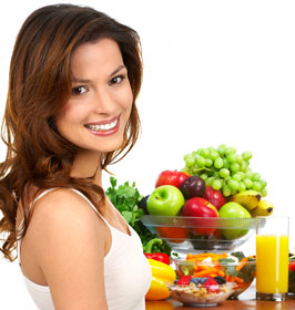 smiling woman with healthy fruits and vegetables