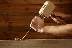 carpenter using a wood mallet and a chisel